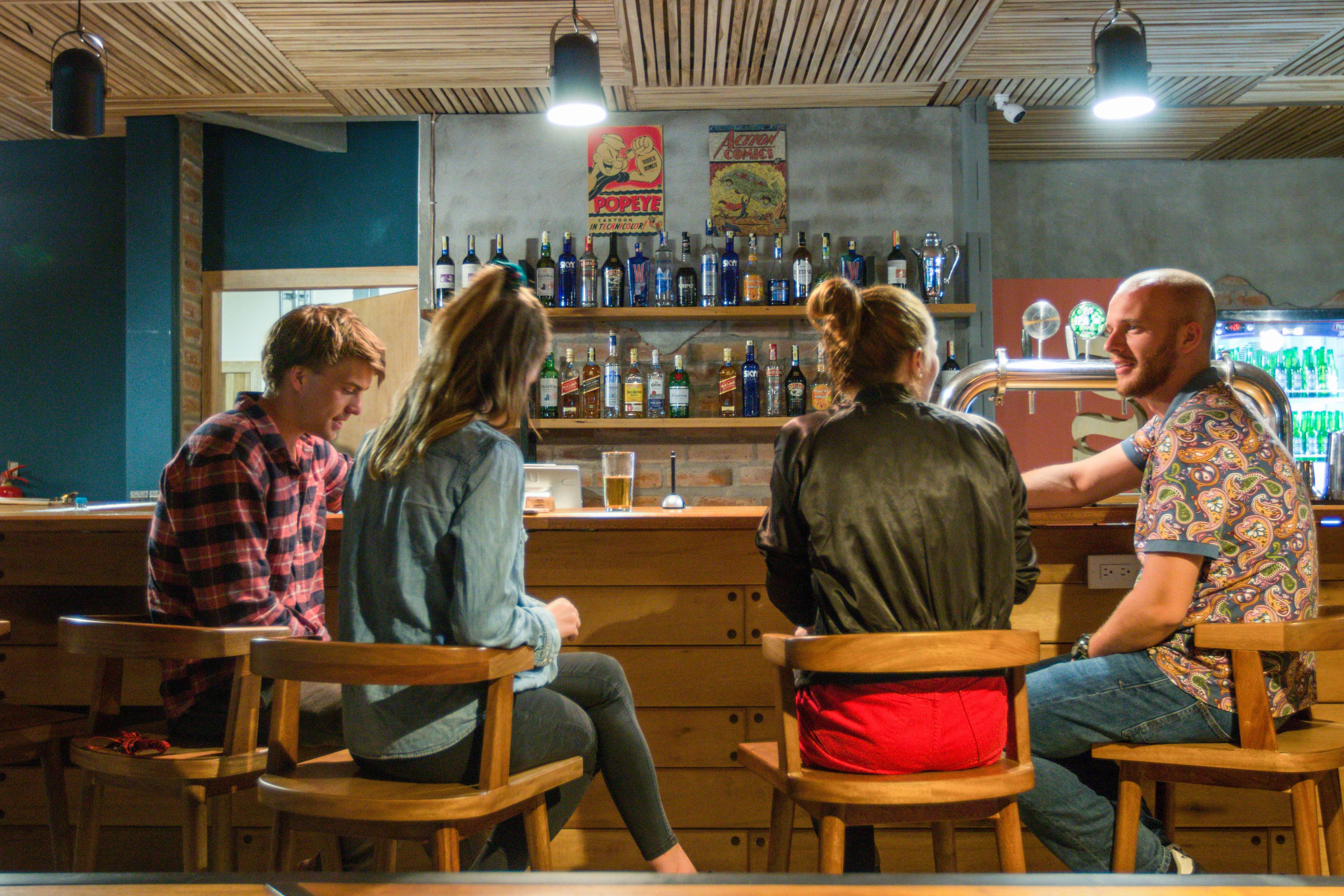 Un bar con mobiliario de madera y una variedad de botellas en estanterías.