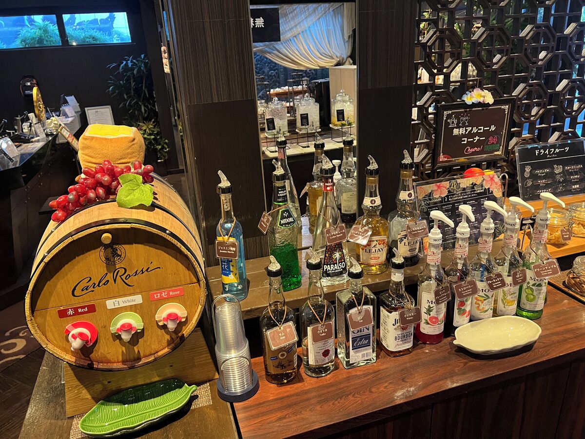 A bar area with a wooden barrel labeled "Carlo Rossi" and various bottles of liquor.
