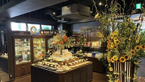 Un espacio comercial moderno con un mostrador central de exhibición, secciones refrigeradas y una gran variedad de productos.