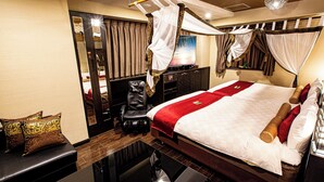 Una habitación de hotel con cama, escritorio, silla y espejo.