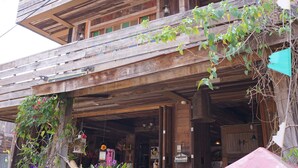 A wooden building with a balcony, a hammock, and a red mailbox. - Chiangkhanburi (Chiang Khan)