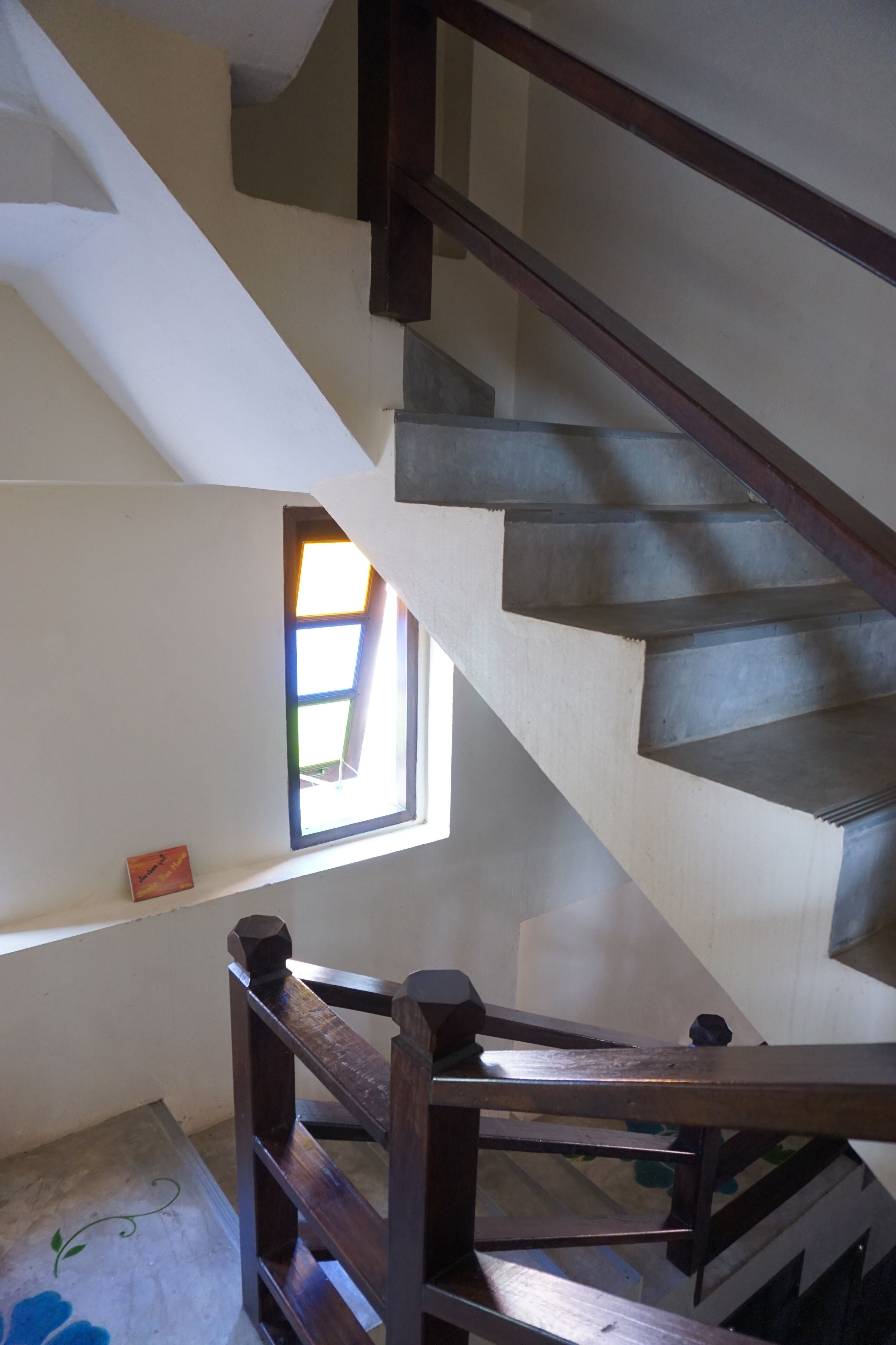 Eine Treppe mit Holzwertlauf und einem Fenster mit Blick ins Freie.