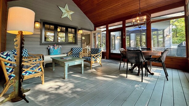 A covered porch with wicker furniture, a star decoration, and a chandelier.