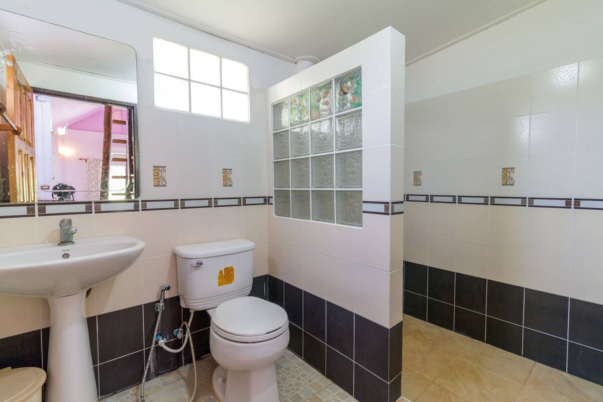 A bathroom with a sink, toilet, and shower area.