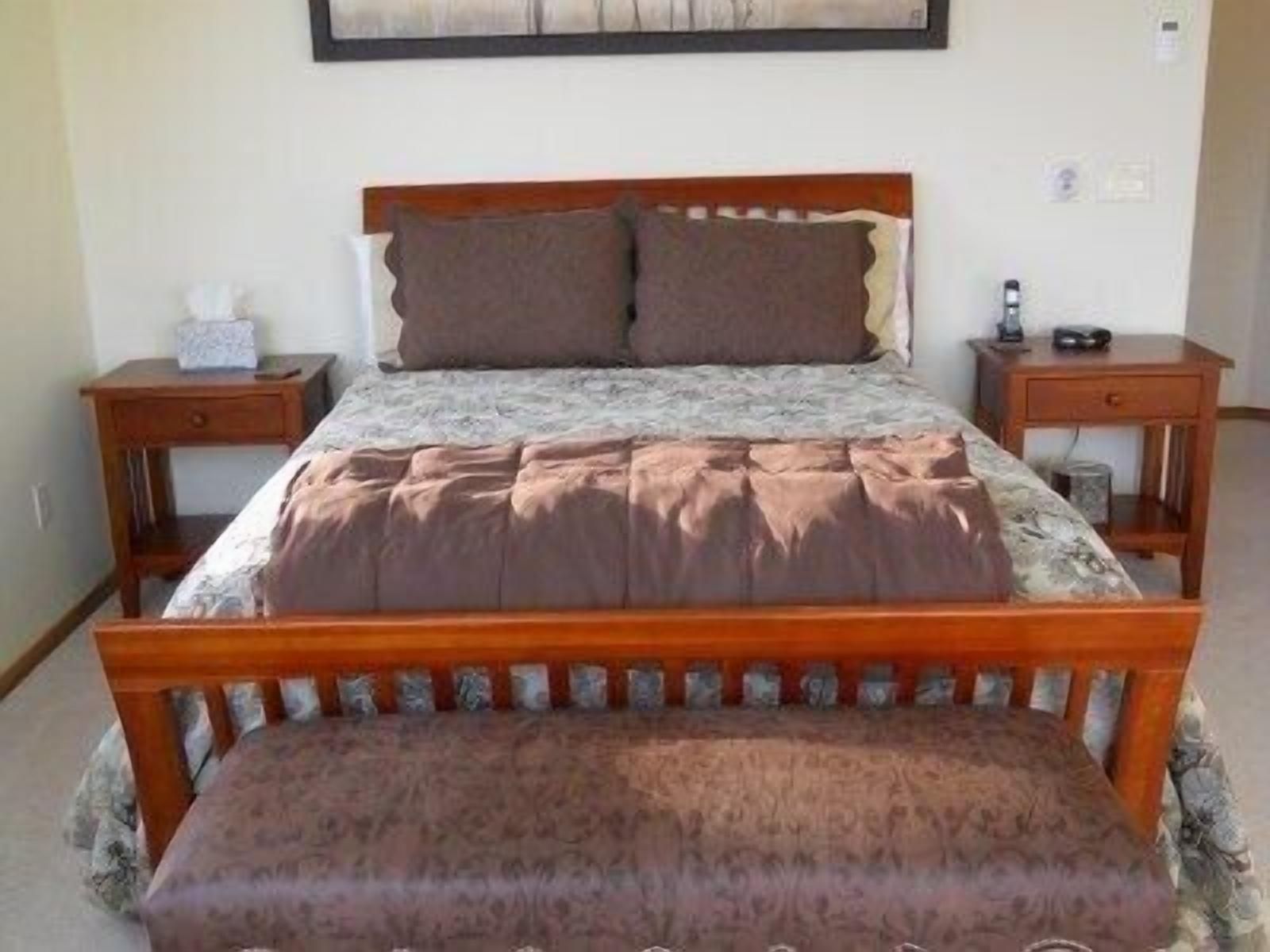 A bedroom with a wooden bed, a bedside table, and a nightstand.