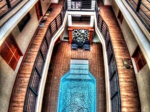 A pool with a stone wall and a wooden deck. - Hidden Pearl Hotel - Janus Luxury Suites (Angeles City)