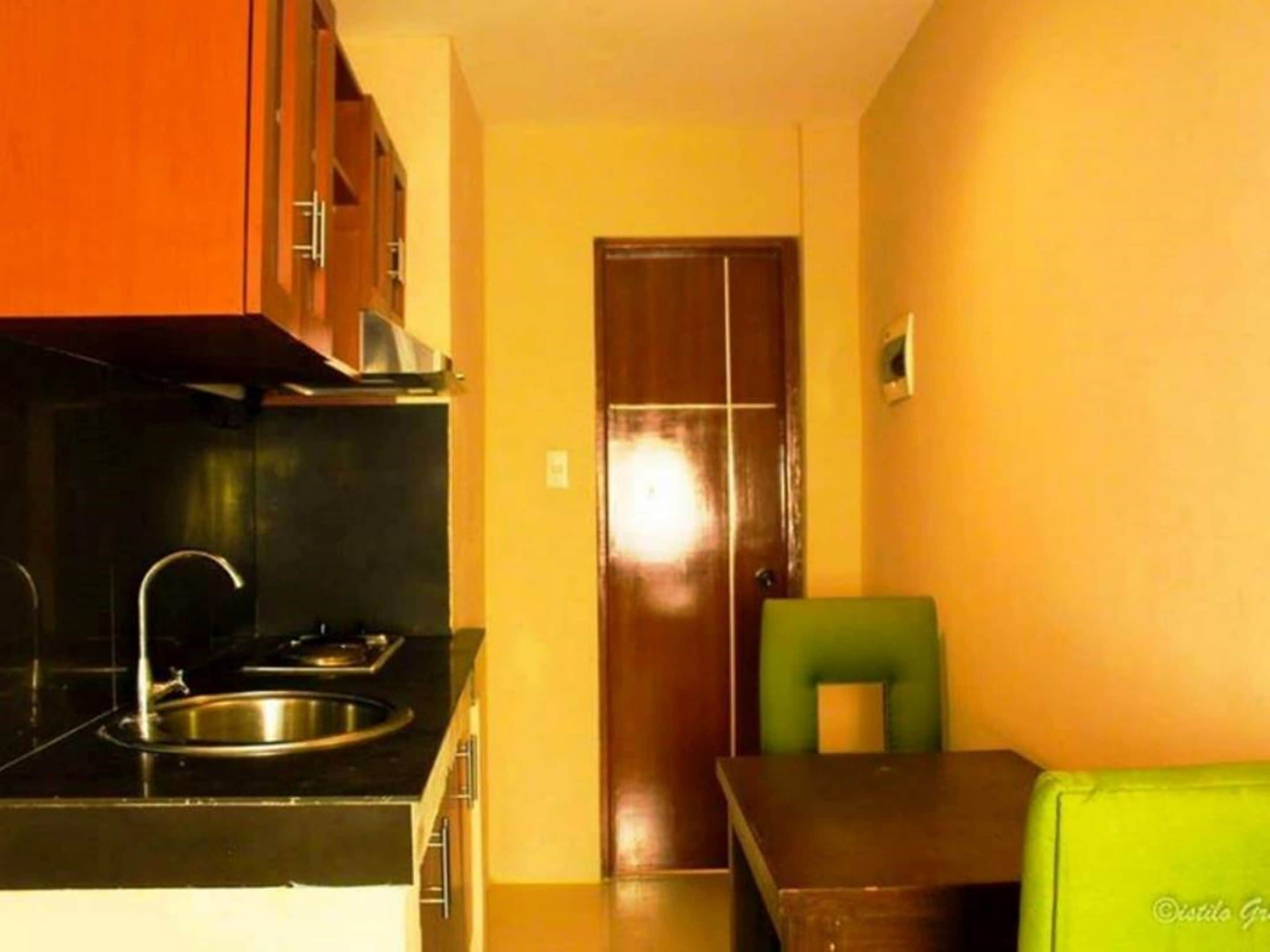 Una cucina compatta con fornello, lavello e pensili.