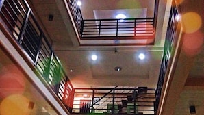 Un intérieur à plusieurs niveaux, doté de balcons, de rampes et d’un luminaire central.