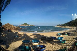 A beach with several boats on the sand and the ocean in the background. - Confetti House (Quy Nhon)