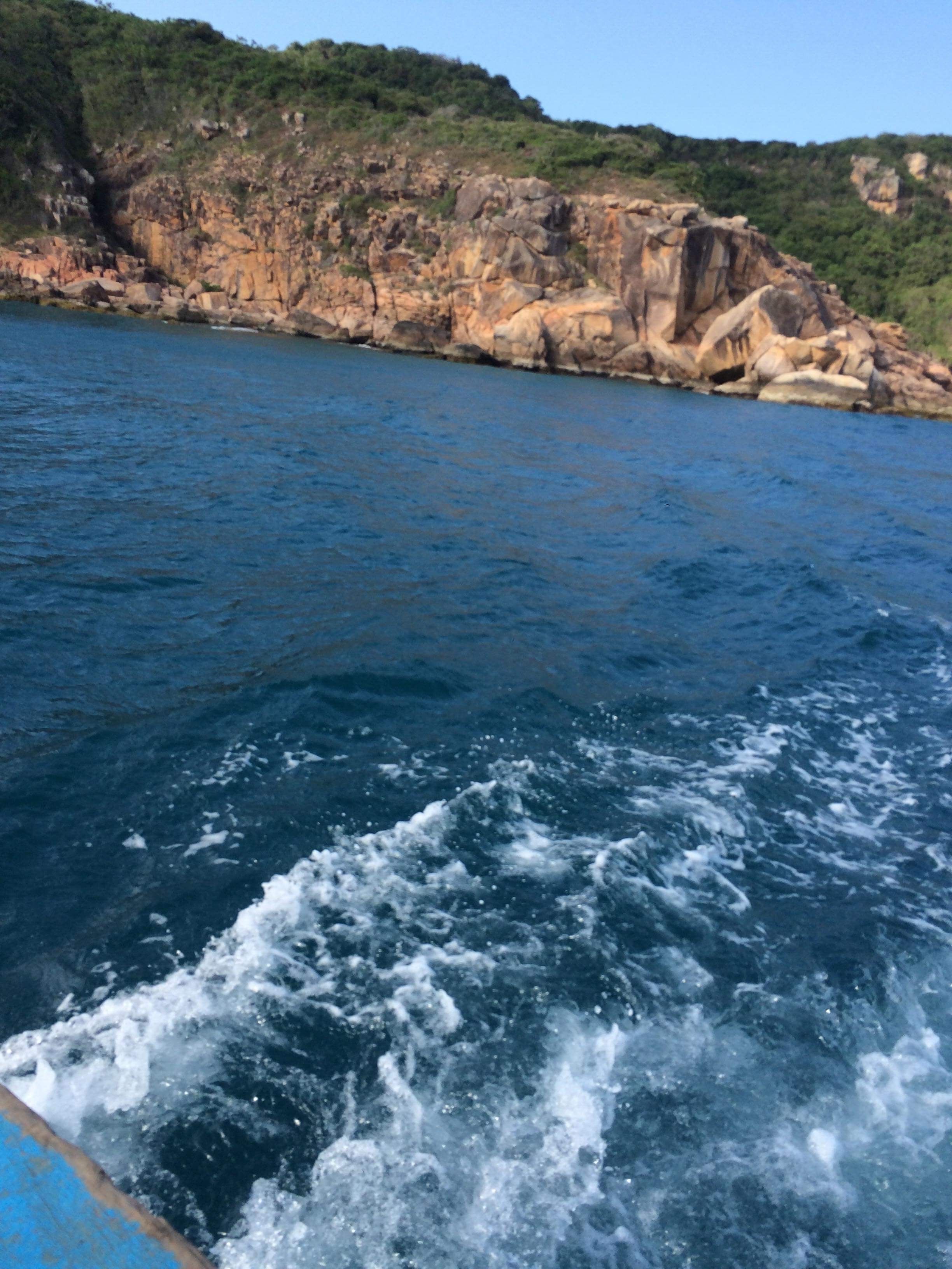 A coastal landscape with rocky cliffs and calm sea.