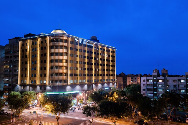 Um hotel de vários andares com uma cúpula imponente no topo, exibindo uma placa com a inscrição "Hotel Chaisal".