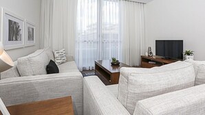 Una sala de estar moderna con un juego de sofá, un televisor y una mesa de centro.