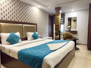 A hotel room with a large bed, a desk, and a chair. - Hotel Pawan Plaza - Near BLK and Ganga Ram Hospital - Karol Bagh (New Delhi)