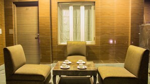 A room with a wooden door marked 407, a window with blinds, two armchairs, and a table with four cups and saucers. - Hotel Pawan Plaza - Near BLK and Ganga Ram Hospital - Karol Bagh (New Delhi)