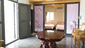 Una habitación con techo de madera, una mesa redonda y dos camas con ropa de cama rosa.