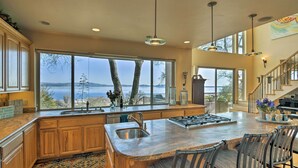 A spacious kitchen with a large island, wooden cabinets, and a view of the ocean. - 'Casa d'Amore': Extravagant Lakefront Villa! (Granite Bay)
