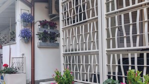 Ein Gebäude mit weißer Fassade, einem Metallzaun und Blumenkästen.