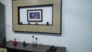 A framed artwork on a wall above a desk with various decorative items. - East End Retreat (New Delhi)
