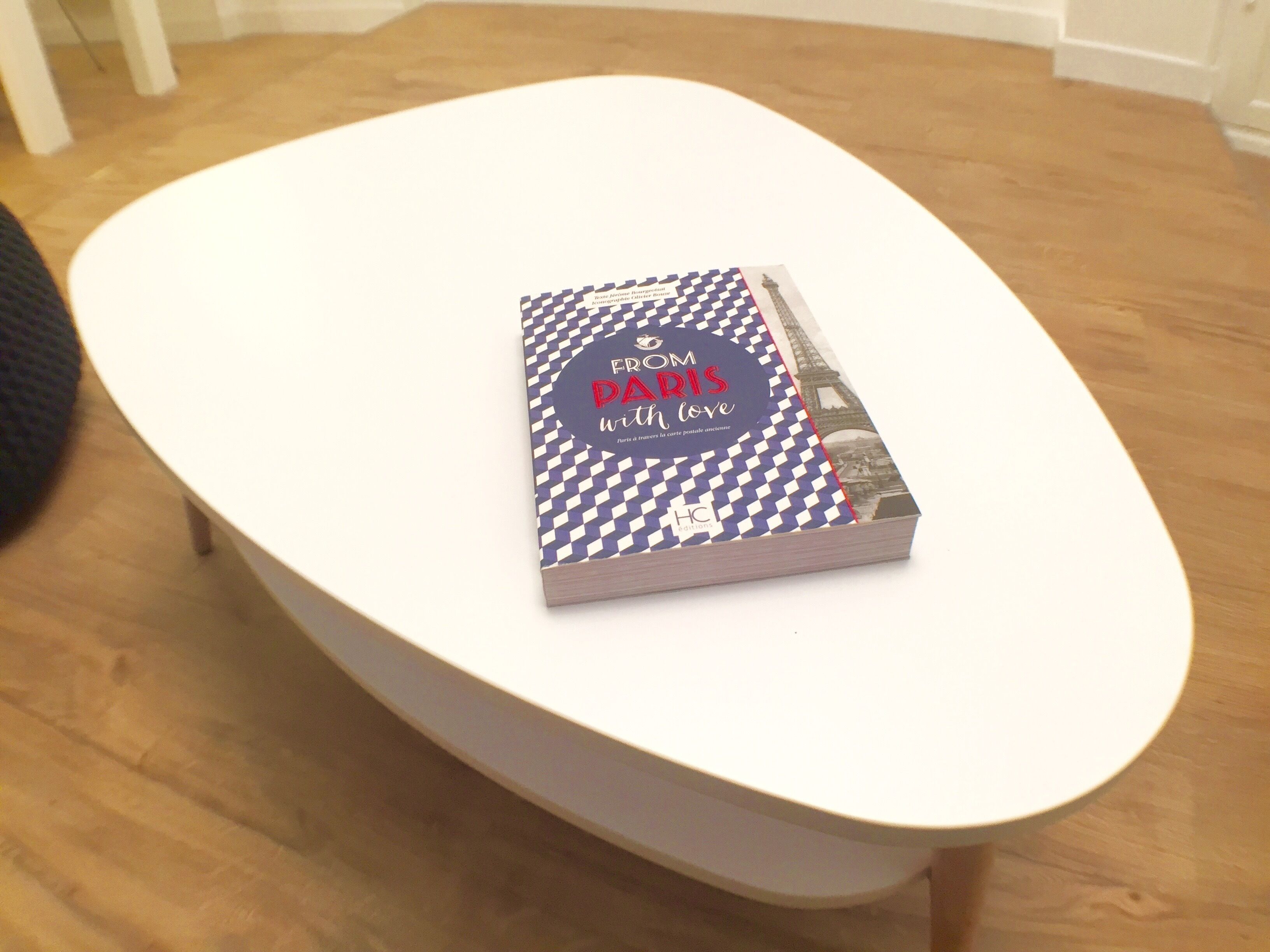 Un libro con el título 'From Paris with love' sobre una mesa blanca y ovalada.