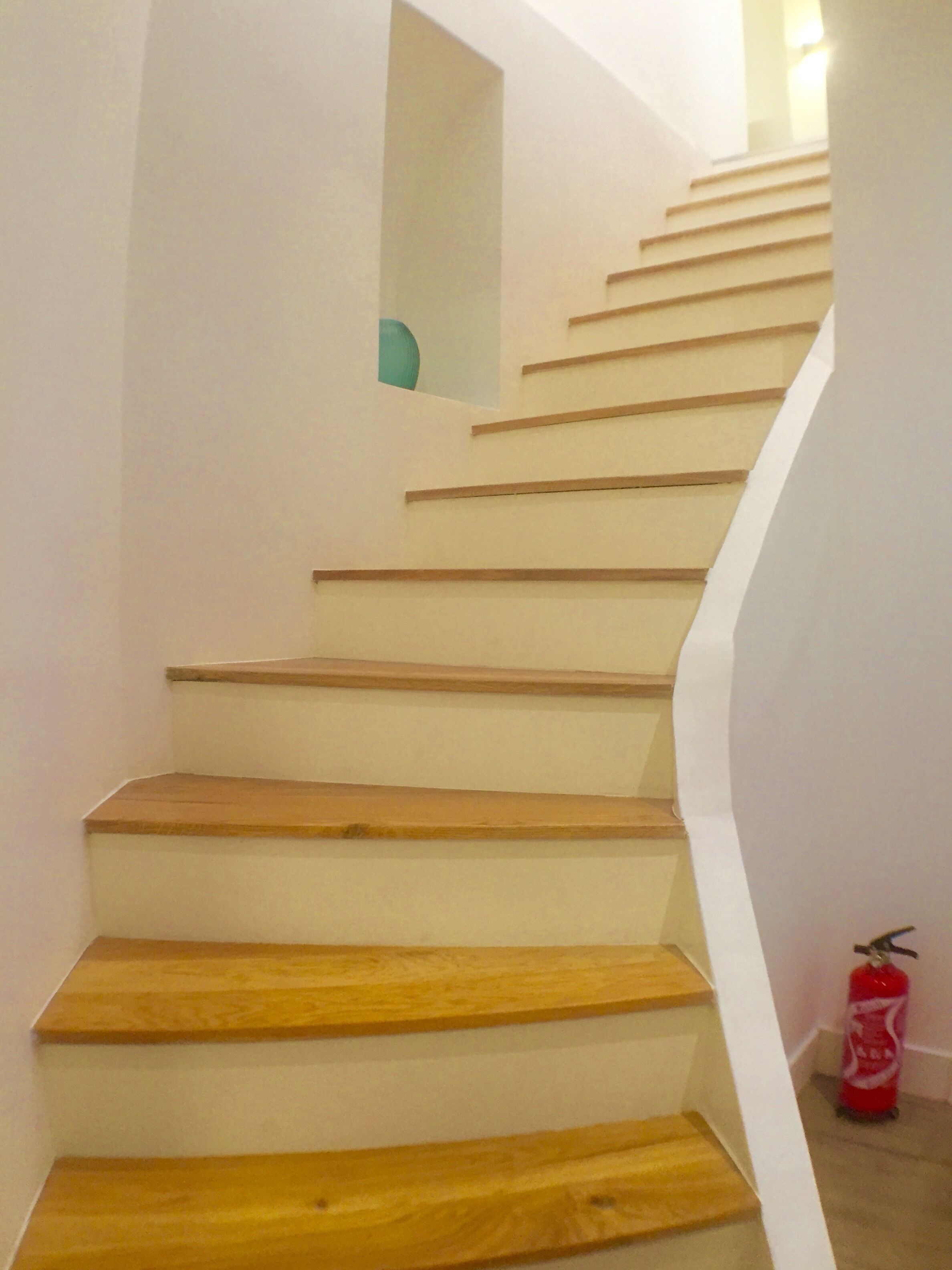 A staircase with wooden steps and white walls.
