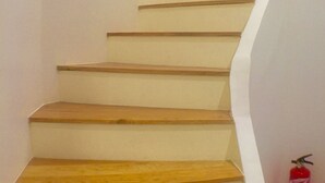Una escalera con escalones de madera y paredes blancas.