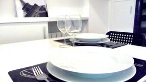 A dining table set with plates, glasses, and cutlery. - Charming duplex in Montmartre (Paris)