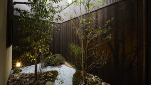 A garden with a gravel path, rocks, and trees. - Rinn Miyagawacho Tsubaki (Kyoto)