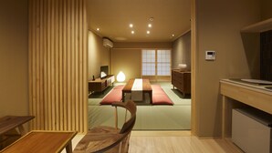 A traditional Japanese-style room with tatami flooring, a low wooden table, a cushioned bench, and a sliding door. - Rinn Miyagawacho Tsubaki (Kyoto)