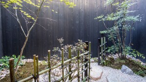 A wooden fence with a bamboo structure in a garden setting. - Rinn Manjuji (Kyoto)