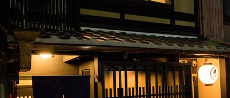 Un edificio japonés tradicional con fachada de madera, tejado de tejas y un farol.