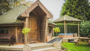 A wooden cabin with a porch, a hot tub, and a gazebo. - Burton Lodge Guest House and Spa (Driffield)