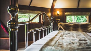 A bedroom with a bed, a wooden headboard, and a window with a view of greenery. - Burton Lodge Guest House and Spa (Driffield)
