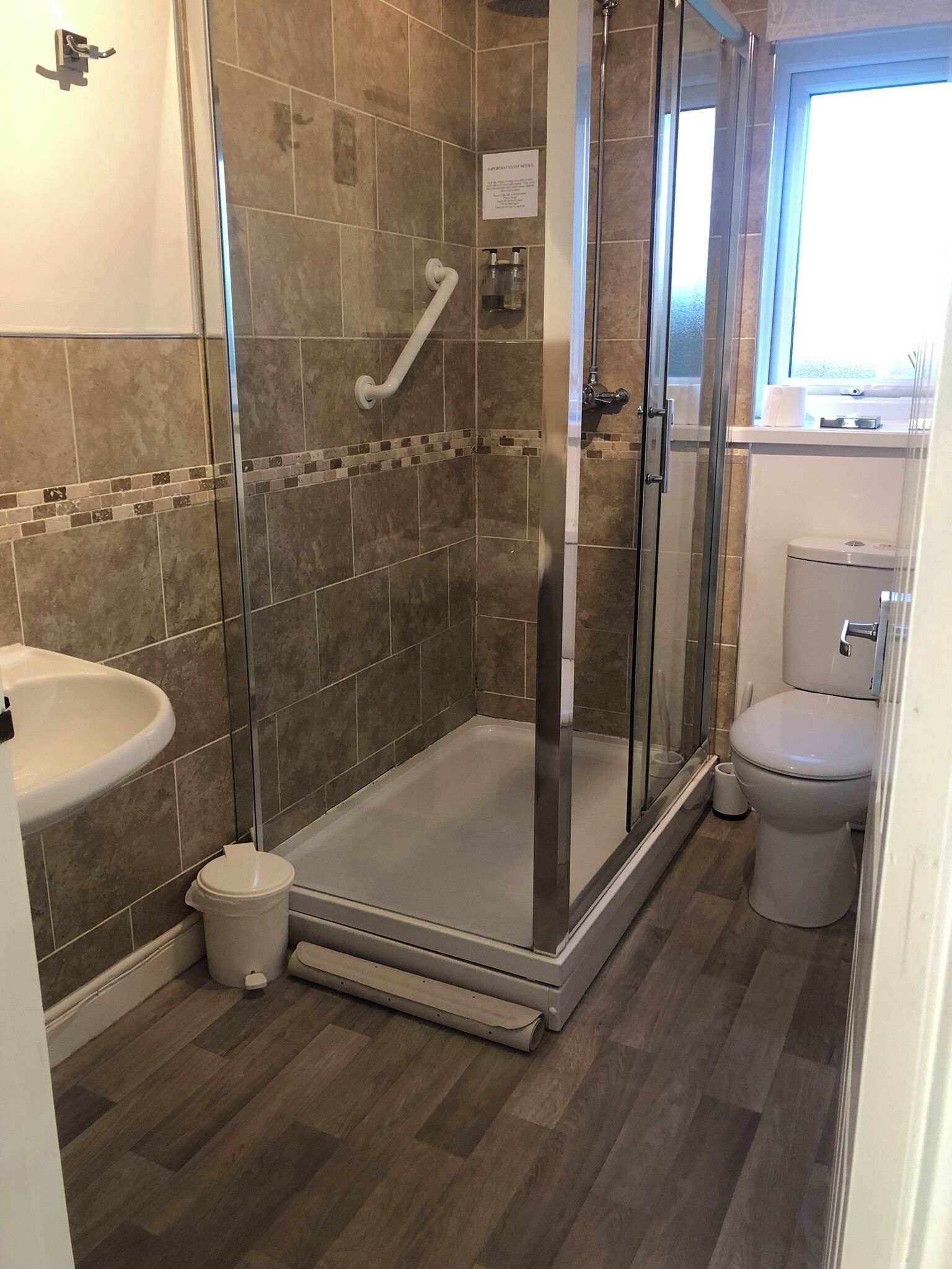 A modern bathroom with a glass shower enclosure, a toilet, and a sink.