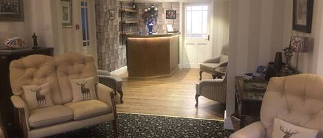 A spacious living area with a fireplace, a bar area, and a patterned rug.