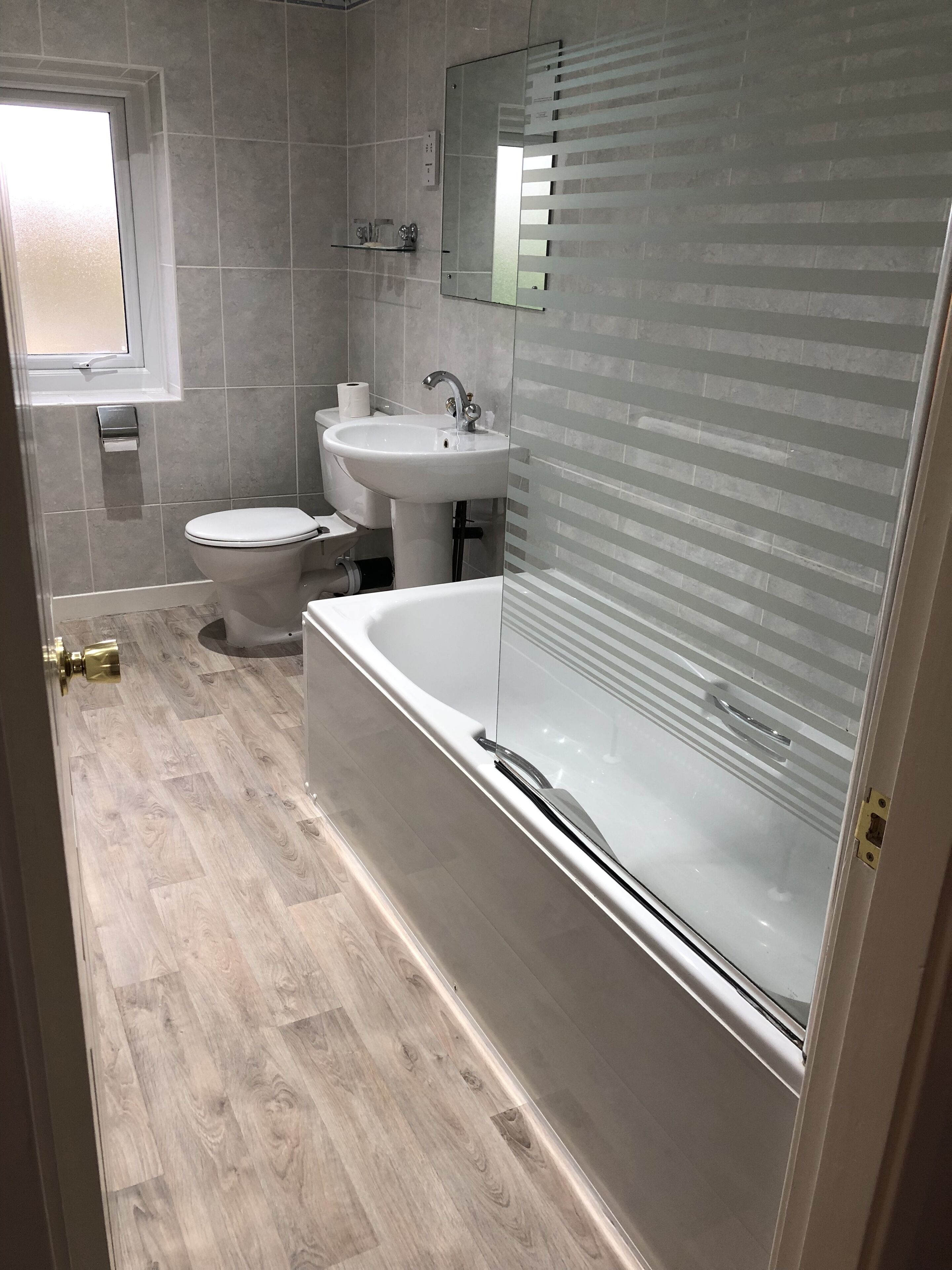 A modern bathroom with a toilet, sink, and bathtub.