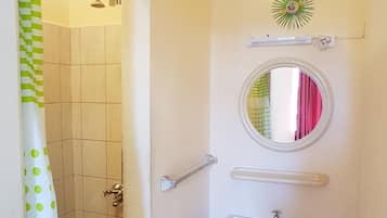 Un baño con ducha, lavabo y espejo.