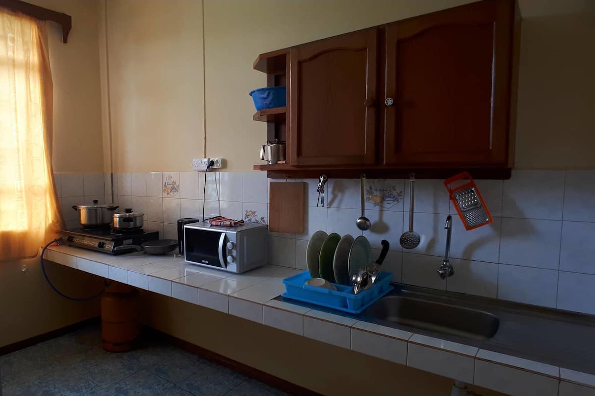 A kitchen with a gas stove, a toaster, and a sink.