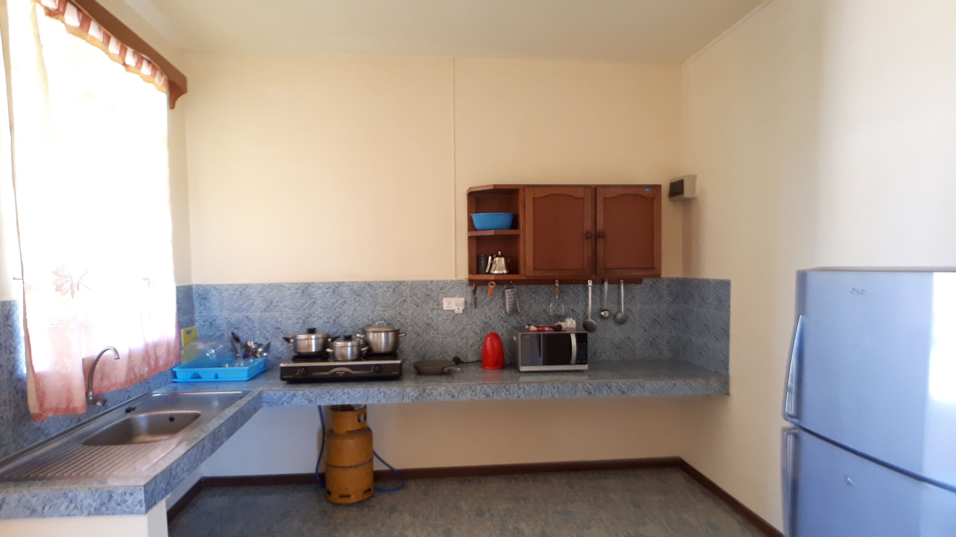 A compact kitchen with a sink, stove, microwave, and cabinets.