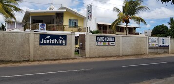 Un edificio con un cartel para un centro de buceo y un cartel para Justdiving.