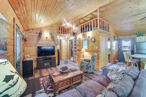 L’intérieur d’une cabane en bois comprend un salon, un coin repas et une chambre à coucher située en mezzanine.