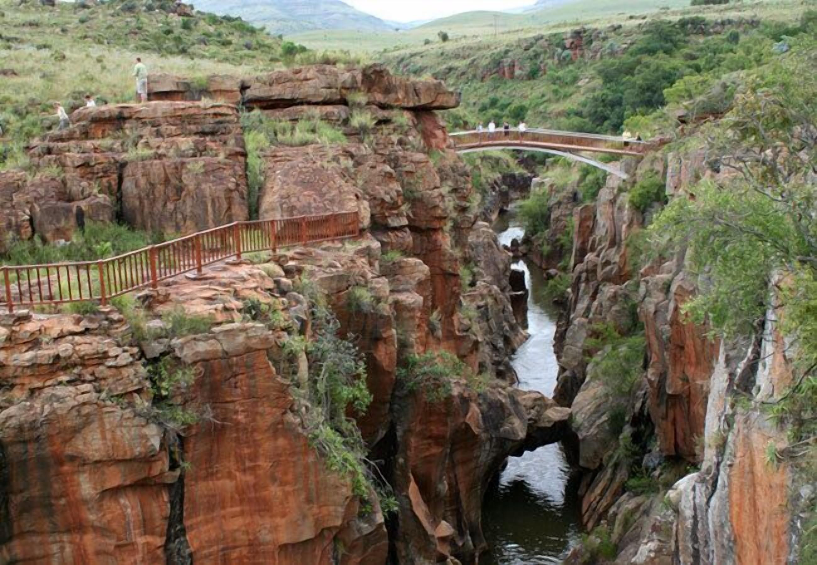 A natural rock formation with a bridge and a pathway.
