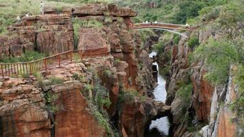 A natural rock formation with a bridge and a pathway.