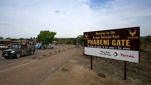 A sign welcoming visitors to Kruger National Park at the Phabeni Gate, with a logo for Total and a slogan about taking pride in heritage. - Log Cabin & Settlers Village (Graskop)