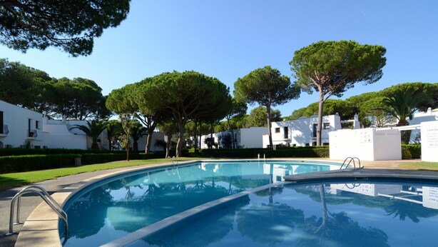 A swimming pool with a ladder, surrounded by white buildings and trees. - PIVERD DEL GOLF 74 (Pals)