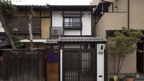 A traditional Japanese house with a wooden gate, a small balcony, and a potted plant. - Holiday home Nijo Sikibu An Kyoto (Kyoto)