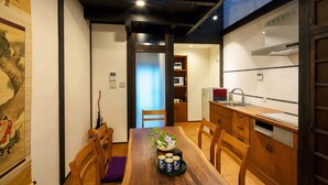 A traditional Japanese-style dining room with a wooden table, chairs, and a vase of flowers. - Holiday home Nijo Sikibu An Kyoto (Kyoto)