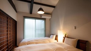 A bedroom with a large bed, wooden headboard, and a window with blinds. - Holiday home Nijo Sikibu An Kyoto (Kyoto)