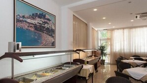 A hotel dining area with buffet counters, tables, and chairs. - Thalia Hotel (Rhodes)