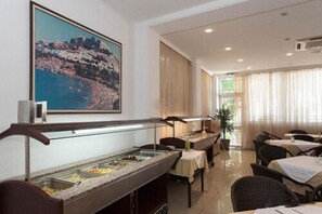 Ein Hotelrestaurant mit Buffettheken, Tischen und Stühlen.