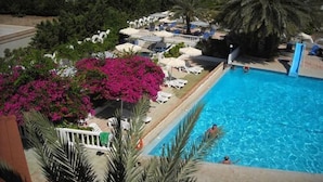 A swimming pool with lounge chairs and a palm tree. - Thalia Hotel (Rhodes)